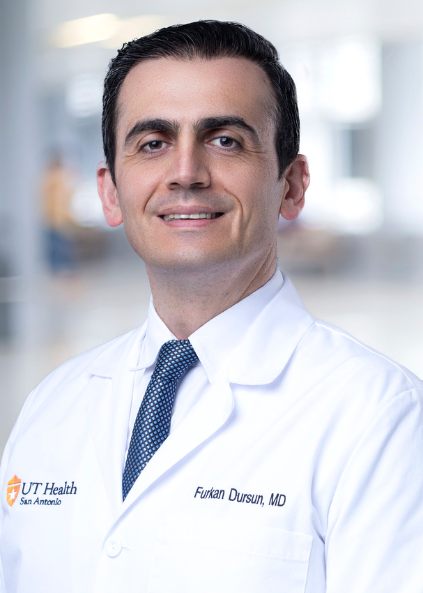Dr. Furkan Dursun in his white coat, smiling.