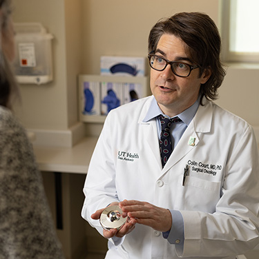 Dr. Court showing the HAI pump device to a patient