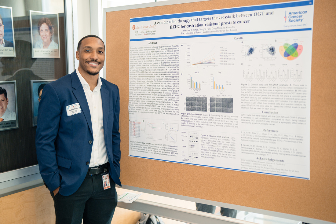 A man standing by his poster presentation