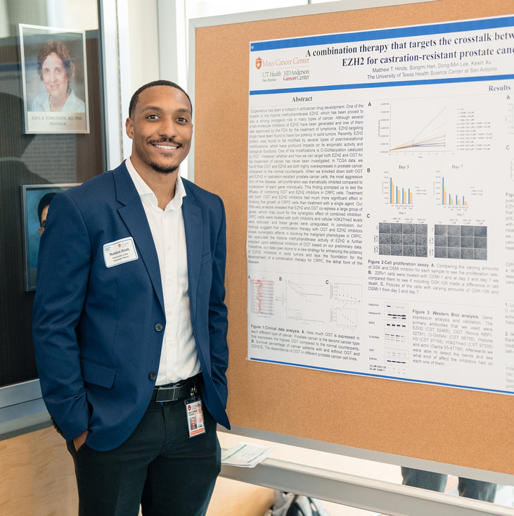 A man standing by his poster presentation