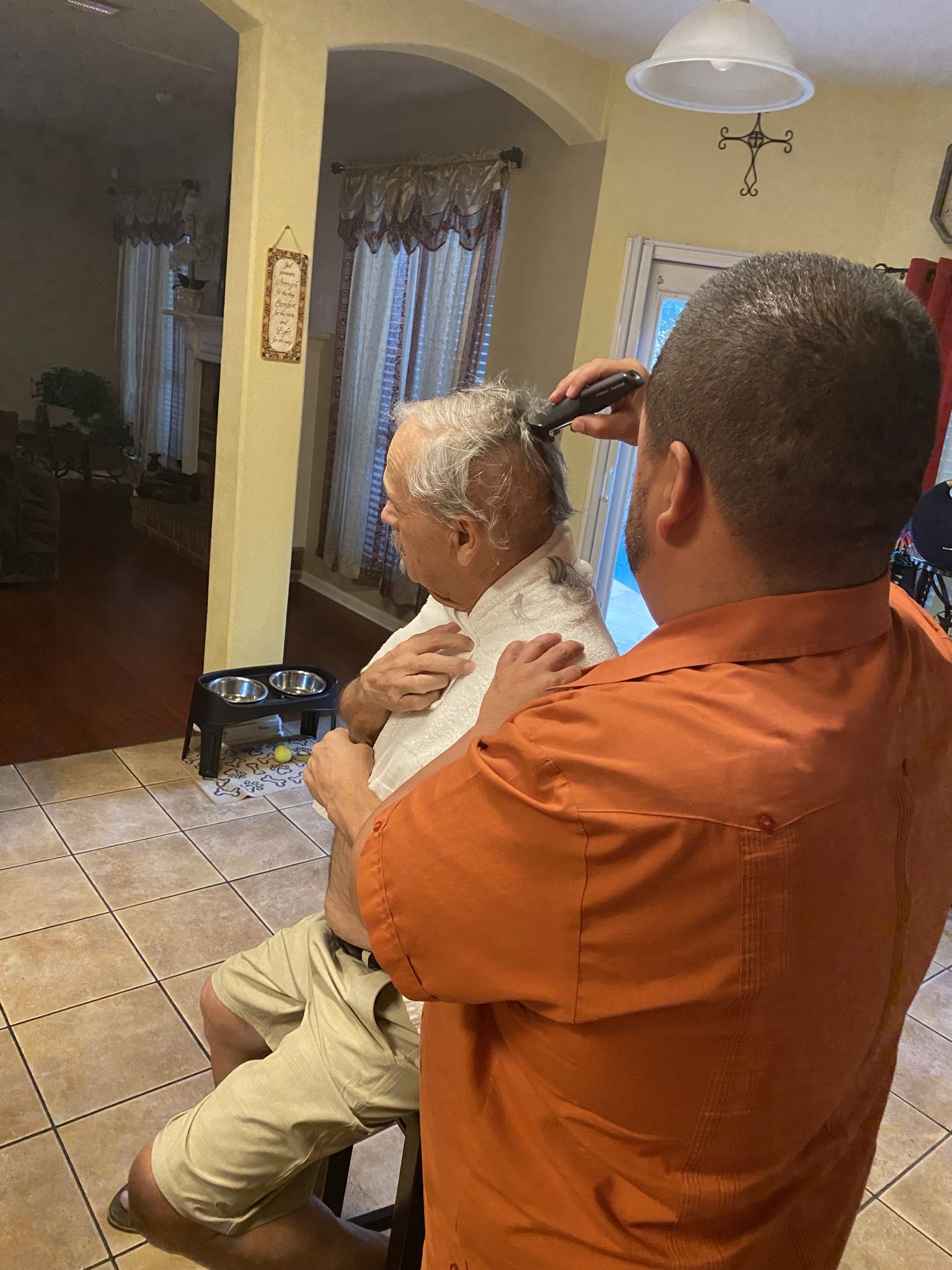 Willie Durazo, III shaves the hair of his father, Willie Durazo, Jr.
