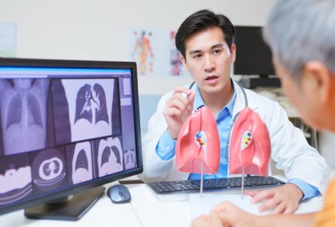 medical consultation - closeup back view asian elderly patient discussing lung health and ct scan x-ray results with doctor using organ model in the clinic